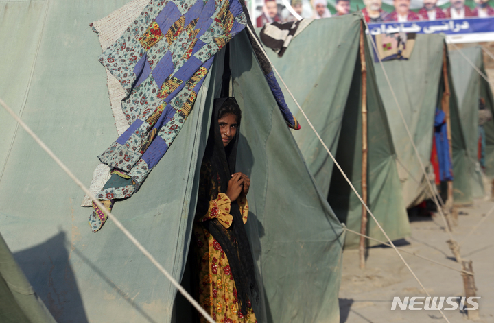 [시카르푸르=AP/뉴시스] 8월 31일(현지시간) 파키스탄 신드주 시카르푸르 수재민 캠프에서 한 소녀가 텐트 밖을 내다보고 있다. 파키스탄 '최악의 홍수'로 1100명 이상이 숨지고 국토 3분의 1이 침수된 가운데 현지 당국은 콜레라 등 수인성 질병 확산을 우려하고 있다. 2022.09.01. 
