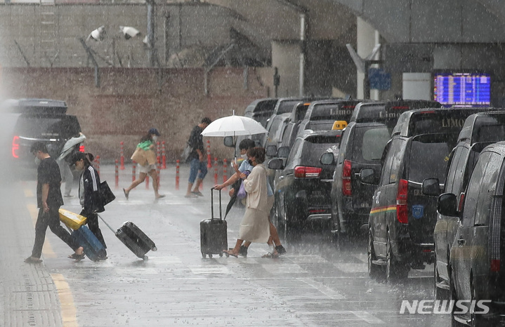 [제주=뉴시스] 제주국제공항에서 관광객들이 비를 피해 이동하고 있다. (사진=뉴시스 DB). photo@newsis.com 