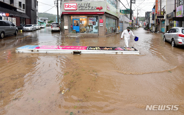 [포항=뉴시스] 이무열 기자 = 제11호 태풍 힌남노가 포항을 강타한 6일 오전 경북 포항시 구룡포읍에서 한 시민이 강풍에 쓰러진 간판을 옮기고 있다. 2022.09.06. lmy@newsis.com