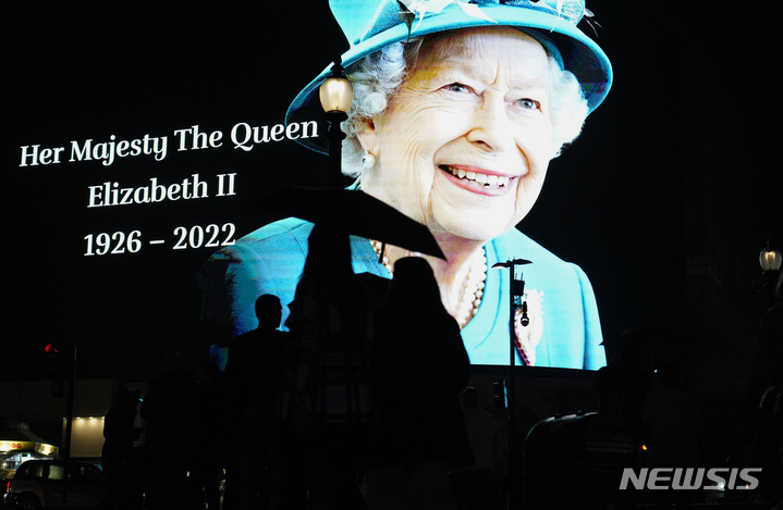 [런던=AP/뉴시스] 8일(현지시간) 영국 런던의 피커딜리 서커스 대형 스크린에 엘리자베스 2세 여왕의 사진이 투영되고 있다. 엘리자베스 2세 영국 여왕이 즉위 70년 만에 96세 나이로 서거했다. 2022.09.09. 