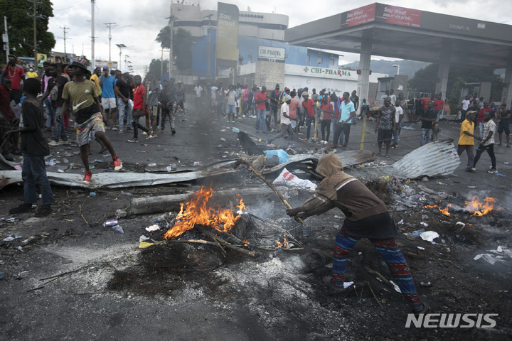 [포르토프랭스=AP/뉴시스] 19일(현지시간) 아이티 포르토프랭스에서 연료 가격 인상에 항의하는 시위대가 아리엘 앙리 총리의 퇴진을 요구하며 도로를 막고 불을 지르고 있다. 2022.09.20.