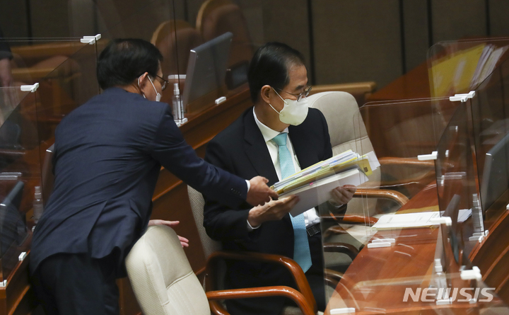 [서울=뉴시스] 김선웅 기자 = 한덕수 국무총리가 20일 서울 여의도 국회에서 열린 본회의에 출석해 관계자로부터 자료를 건네받고 있다. (공동취재사진) 2022.09.20. photo@newsis.com