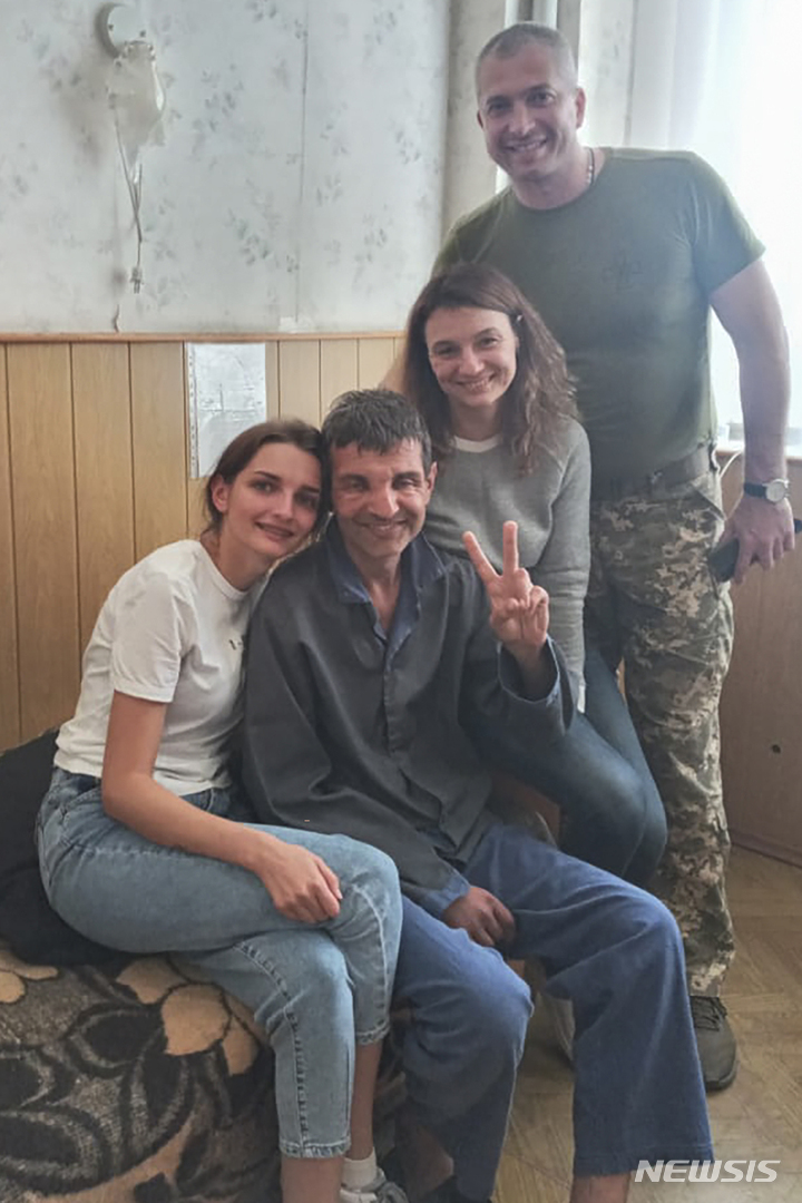 [체르니히우=AP/뉴시스] 러시아와 우크라이나의 포로 교환으로 석방된 한 우크라이나 군인이 22일(현지시간) 우크라이나 체르니히우 시립병원에서 친지를 만나 V를 그리고 있다. 2022.09.23.