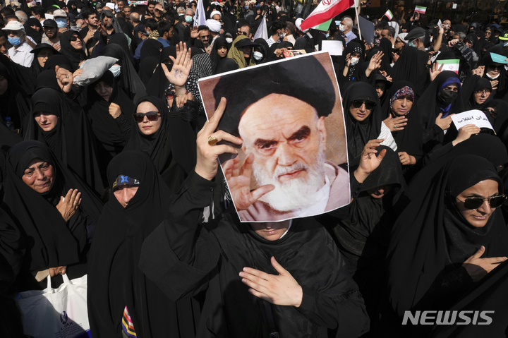 [테헤란=AP/뉴시스] 23일(현지시간) 이란 수도 테헤란에서 친정부 시위자가 이슬람 혁명을 주도했던 아야톨라 루홀라 호메이니의 사진을 들고 시위를 벌이고 있다. 2022.09.24