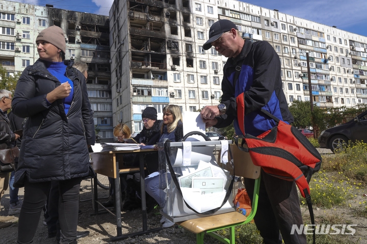 [도네츠크=AP/뉴시스] 지난 24일(현지시간) 우크라이나 동부 친러 성향의 도네츠크인민공화국(DPR)에서 합병을 위한 주민투표가 진행 중이다. 현지 주민들이 투명 투표함에 기표한 투표용지를 넣고 있다. 2022.09.24.
