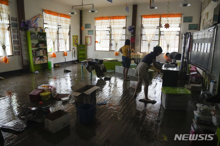 [불라칸=AP/뉴시스] 26일(현지시간) 필리핀 불라칸주 산미구엘에서 학교 선생님과 그녀의 딸이 태풍 '노루'로 진흙탕이 된 교실 안을 청소하고 있다. 2022.09.27.