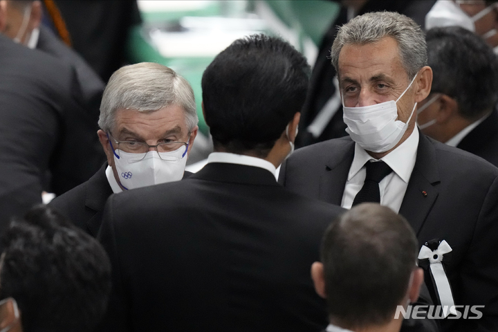 [도쿄=AP/뉴시스] 27일 일본 도쿄 부도칸에서 암살된 아베 신조 전 총리의 국장에 토마스 바흐(왼쪽), 니콜라스 사르코지 전 프랑스 대통령이 도착하고 있다. 2022.09.27.