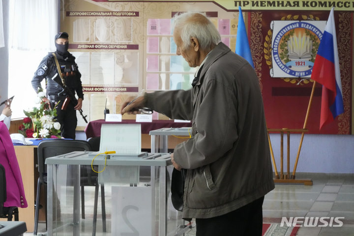 [루한스크=AP/뉴시스] 한 남성이 27일(현지시간) 우크라이나 동부 루한스크주에서 열린 국민 투표에 참여해 투표 용지를 투표함에 넣고 있다. 2022.09.28.