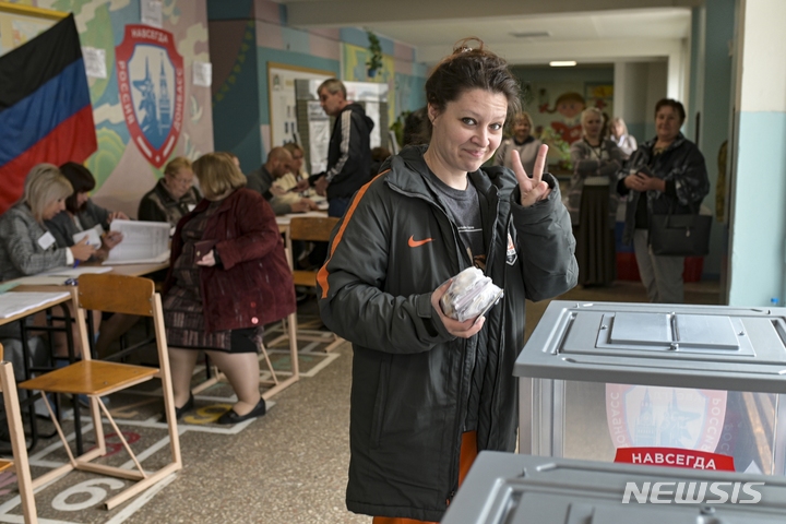[도네츠크=AP/뉴시스] 한 여성이 27일(현지시간) 우크라이나 동부 도네츠크 인민공화국의 수도 도네츠크 투표장에서 투표한 뒤 사진작가를 향해 포즈를 취하고 있다. 2022.09.28.