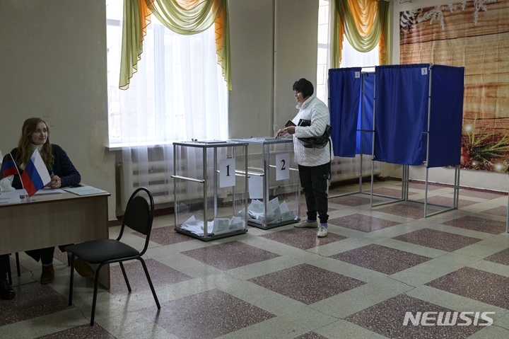 [도네츠크=AP/뉴시스] 27일(현지시간) 러시아 동부 도네츠크주에서 한 여성이 투표장에서 열린 국민투표에 참여하고 있다. 2022.09.28.