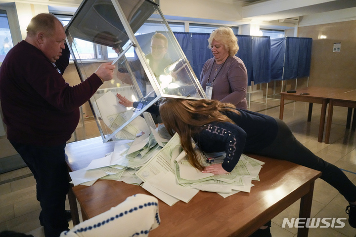 [루한스크=AP/뉴시스] 27일(현지시간) 우크라이나 동부 루한스크 인민공화국에서 국민투표회 위원들이 러시아의 영토 편입을 위해 실시된 국민투표에서 투표함을 비우고 있다. 2022.09.28. 