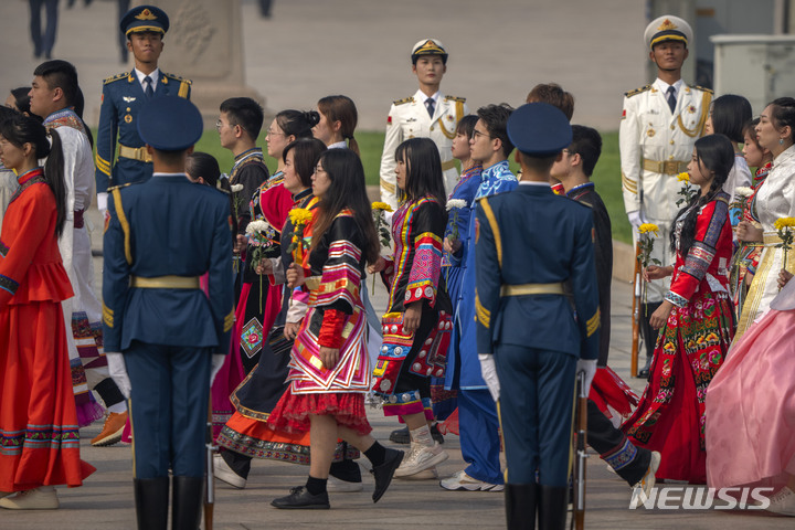 [베이징=AP/뉴시스] 30일 중국 베이징의 톈안먼 광장 인민영웅기념비에서 제9회 열사기념일 행사가 열려 전통의상을 입은 소수민족 복장을 한 참석자들이 헌화하고 있다. 중국은 건국 73주년인 국경절(10월 1일)을 하루 앞두고 순국열사 추모 행사를 열었다. 2022.09.30.