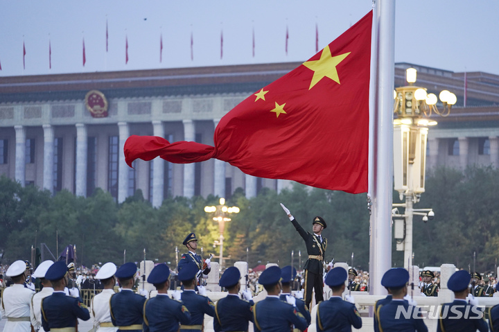 [베이징=AP/뉴시스] 중국 명예 경호원이 1일 중국 베이징 천안문 광장에서 열린 중화인민공화국 건국 73주년 기념 국기 게양식에서 오성홍기를 펼치고 있다. 2022.10.04.