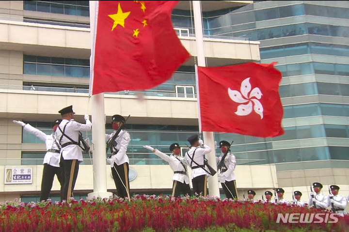 [홍콩=AP/뉴시스] 홍콩 공익규범 장교들이 1일 홍콩 빅토리아 항만 컨벤션 센터 바깥에서 중국과 홍콩의 국기를 들어올리며 중국 국경절을 기념하고 있다. 2022.10.04.