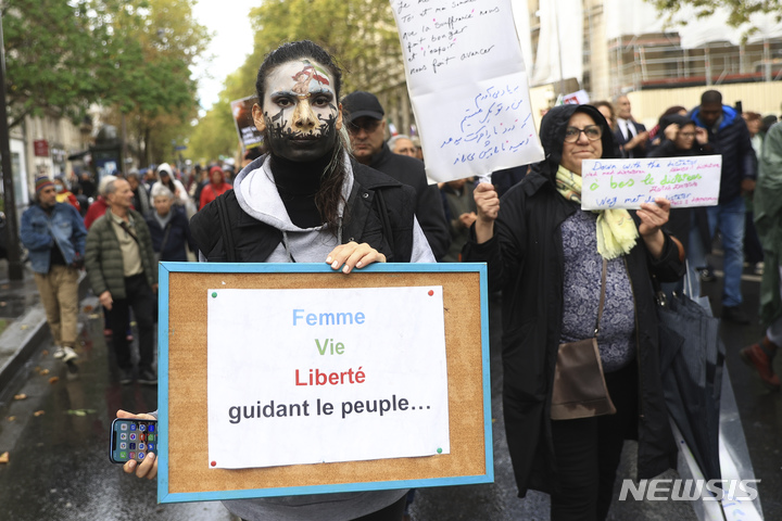 [파리=AP/뉴시스] 시위자들이 2일(현지시간) 프랑스 파리에서  경찰에 구금되던 중 사망한 젊은 여성의 추모를 지지하기 위해 "여성, 국민으로서 살아갈 자유"가 적힌 포스터를 읽으며 시위하고 있다. 2022.10.06.