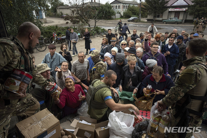 [이지움=AP/뉴시스] 2일(현지시간) 최근 수복된 우크라이나의 이지움 마을에서 군인들이 주민들에게 구호 물품을 나눠주고 있다. 2022.10.03.
