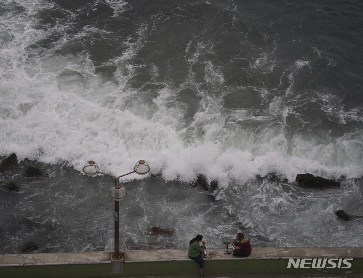 [마사틀란( 멕시코)= AP/뉴시스] 멕시코 마사틀란 해안의 허리케인 올린 풍랑에도 불구하고 10월 2일 관광객들이 파도를 구경하고 있다.   