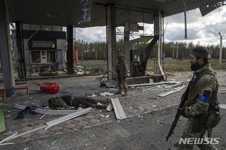 [AP/뉴시스] 러시아군이 퇴각한 지 이틀이 지난 3일 리만의 한 주유소에서 우크라군이 전사한 자군 동료 시신을 발견하고 있다 