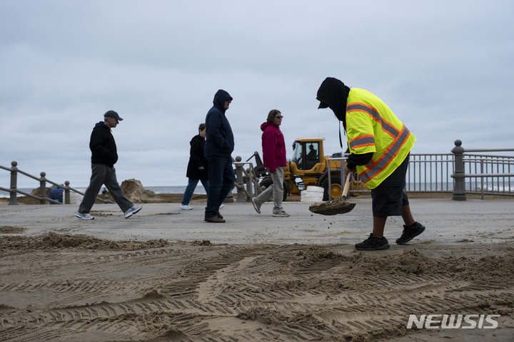 [버지니아=AP/뉴시스]4일(현지시간) 미 버지니아주 세인트 버지니아 비치 앞 오솔길 위로 밀려온 모래를 제거하기 위해 관리인들이 모래를 제거하고 있다. 앞서 허리케인 이언(Ian)이 이곳을 강타했다. 2022.10.5