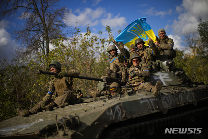 [리만=AP/뉴시스] 우크라이나 군인들이 4일(현지시간) 우크라이나의 이지움과 리만 사이의 도로를 지나는 장갑차 위에 앉아 국기를 들고 있다. 2022.10.05.
