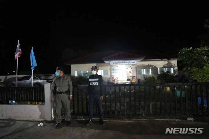 [농부아람푸주=AP/뉴시스] 경찰이 7일(현지시간) 새벽 태국 북동부 농부아람푸주에서 총기 난사 사고가 발생한 어린이 집 바깥에 서있다. 2022.10.07.