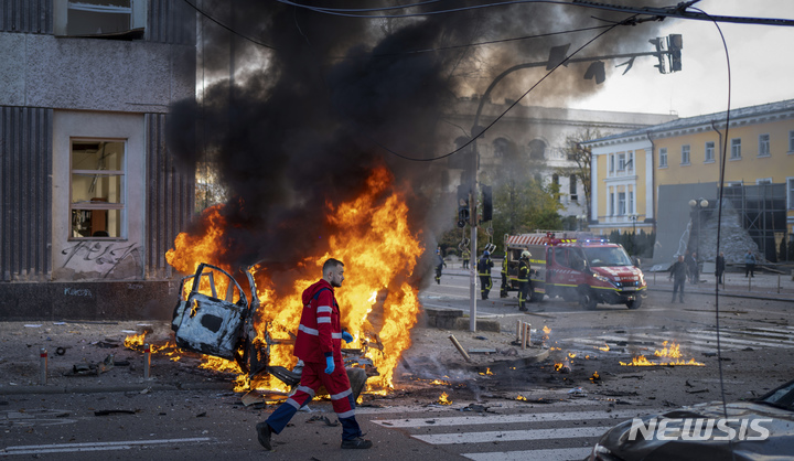 [키이우=AP/뉴시스] 10일(현지시간) 우크라이나 키이우에서 한 구급대원이 러시아의 공습으로 불 타는 차량 앞을 달려가고 있다. 러시아가 크름대교 폭발에 대한 보복으로 키이우를 비롯한 최소 14개 도시에 공습을 감행해 우크라이나인 최소 14명이 숨지고 97명이 다친 것으로 나타났다. 2022.10.11.