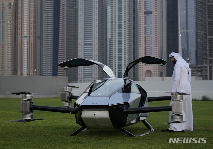 [두바이=AP/뉴시스] 10일(현지시간) 아랍에미리트(UAE) 두바이 마리나 지구에서 한 남성이 중국의 전기차업체 샤오펑이 개발한 전기비행 택시 '샤오펑X2'를 살펴보고 있다. 2022.10.11.