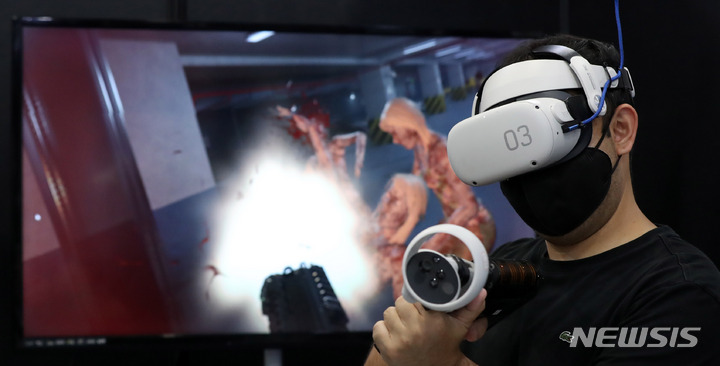 [서울=뉴시스] 추상철 기자 = 13일 오전 서울 강남구 코엑스에서 열린 '메타버스 페스티벌&K-메타버스 엑스포 2022'에서 참가업체 직원이 VR 게임 시연을 하고 있다. 2022.10.13. scchoo@newsis.com