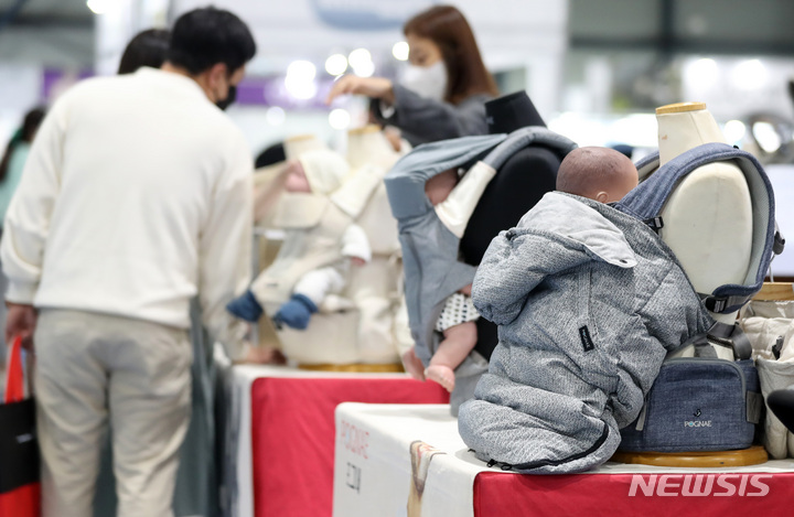 [서울=뉴시스] 이영환 기자 = 13일 오후 서울 강남구 세텍에서 열린 서울경기 베이비페어에서 한 부부가 아기띠를 살펴봅고 있다. 2022.10.13. 20hwan@newsis.com