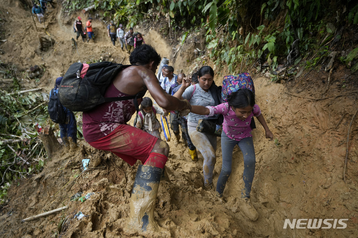 [파나마시티=AP/뉴시스] 콜롬비아-파나마국경의 다리엔 갭의 길도 없는 진흙산을 걷는 이민들 .지난 해 10월 5일 사진.