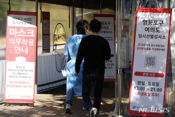 [서울=뉴시스] 백동현 기자 = 코로나19 신규 확진자가 1만4302명으로 집계된 24일 오후 서울 영등포구 여의도공원에 마련된 임시선별검사소에서 한 시민이 PCR검사를 받기 위해 들어가고 있다. 2022.10.24. livertrent@newsis.com