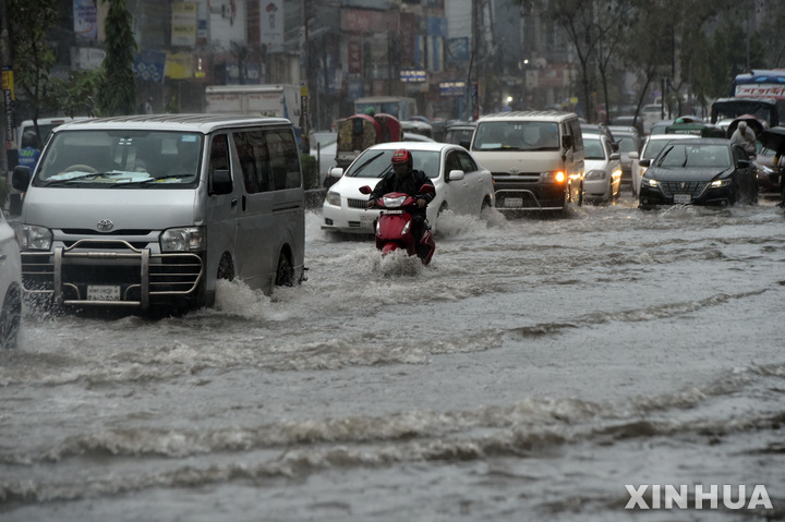 [다카=신화/뉴시스] 2022년 10월 24일 방글라데시 수도 다카에서 오토바이와 자동차들이 물에 잠긴 거리를 운행하고 있다. 방글라데시 대부분 지역에 열대성 저기압 사이클론 시트랑의 영향으로 돌풍을 동반한 폭우가 내리고 있다. 2022.10.25.