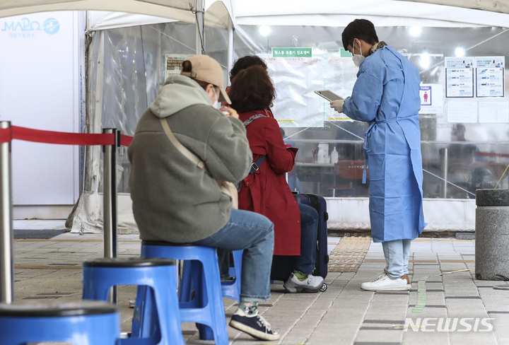 [서울=뉴시스] 김근수 기자 = 국내 코로나19 신규확진자 수가 4만 842명을 기록한 26일 오후 서울시 마포구 보건소 선별진료소에서 시민들이 검사를 받기 위해 대기하고 있다. 2022.10.26. ks@newsis.com