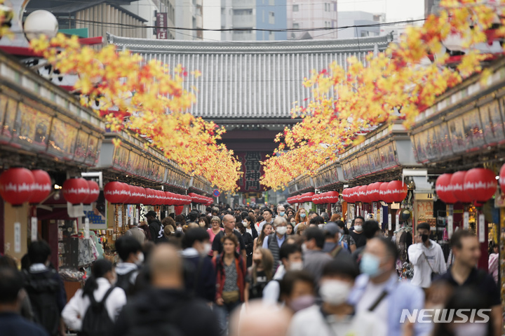 [도쿄=AP/뉴시스]지난 10월17일 일본 도쿄의 관광지인 아사쿠사에 있는 기념품 가게 거리를 관광객들이 걷고 있다. 2022.12.08.