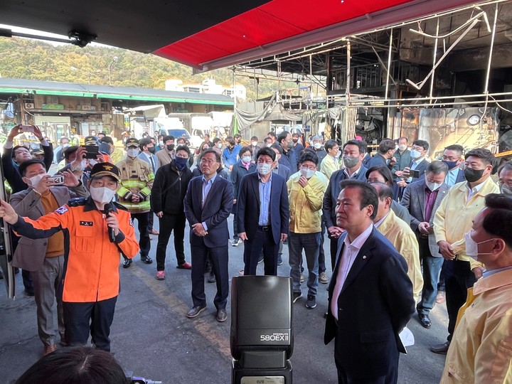 [대구=뉴시스]국민의힘 대구지역 국회의원들이 29일 오전 대형 화재가 발생한 대구시 북구 매천동 농수산물도매시장을 찾아 소방당국 관계자로부터 피해상황을 보고받고 있다. 사진 앞쪽 뒷짐을 진 사람은 김용판 대구시당 위원장이다(사진=국민의힘 대구시당 제공) 2022.10.29 photo@newsis.com *재판매 및 DB 금지