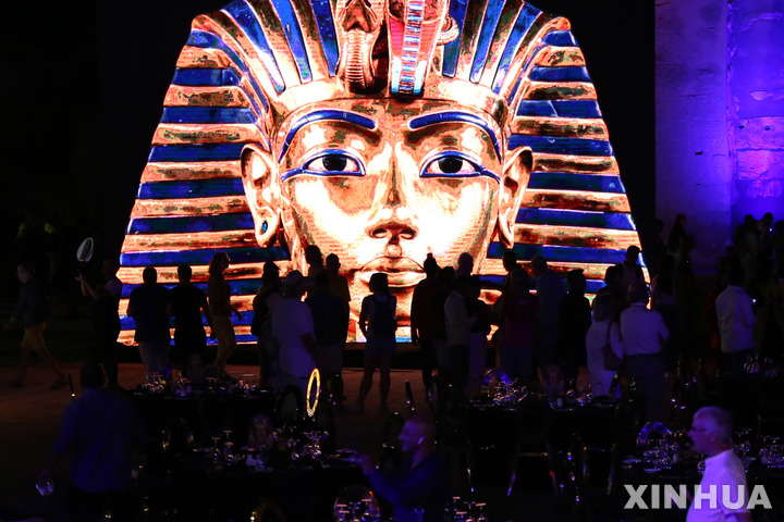 [룩소르( 이집트)= AP/뉴시스] 이집트 룩소르에서 지난 해 11월 4일 개막한 투탄카멘 왕묘 발굴 100주년 기념전의 투탄카멘 왕 조각상앞에서 관광객들이 이를 구경하고 있다.