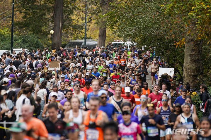 [뉴욕= AP/뉴시스] 6일 개최된 뉴욕 마라톤대회 참가자들이 센트럴 파크의 주로를 통과하며 달리고 있다. 
