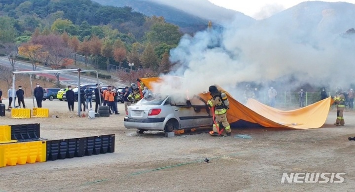 [창원=뉴시스] 홍정명 기자= 경남도소방본부 '질식소화덮개'를 활용한 전기차 화재진압 시연.(사진=경남소방 제공)2022.11.09. photo@newsis.com