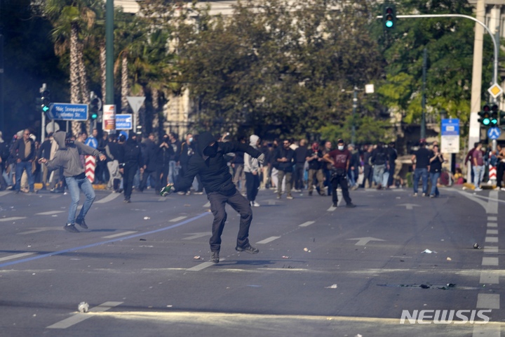 [아테네=AP/뉴시스] 9일(현지시간) 그리스 수도 아테네 의회 외곽에서 시위자들이 경찰을 향해 화염병을 던지고 있다. 이날 아테네에서는 수천명의 시위자들이 고물가에 대한 대책 마련과 임금인상을 촉구했다. 2022.11.11