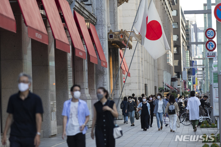 [도쿄=AP/뉴시스]지난 9월23일 일본 도쿄의 한 백화점 거리를 시민들이 코로나19 감염 방지를 위해 마스크를 쓴 채 걸어가고 있다. 2022.12.28.