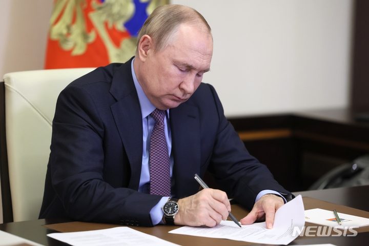 [모스크바=AP/뉴시스] 블라디미르 푸틴 러시아 대통령이 지난달 15일(현지시간) 모스크바 외곽 노보-오가료보 관저에서 서류를 들여다 보고 있다. 2022.12.06.