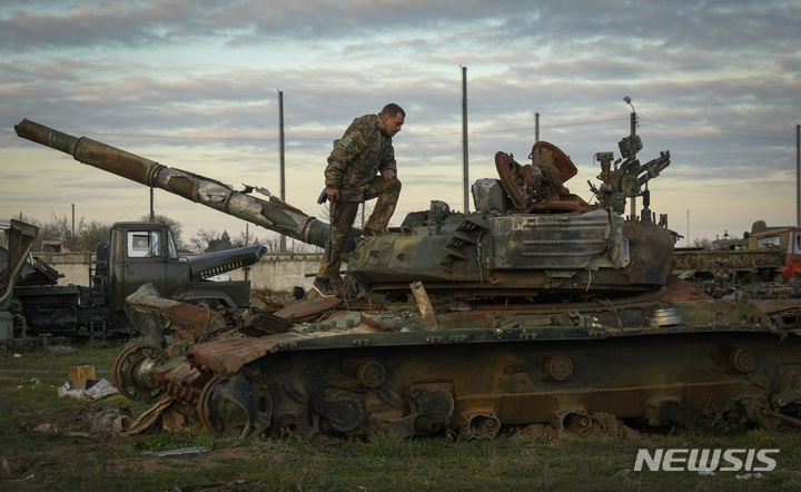 [헤르손=AP/뉴시스] 한 우크라이나 군인이 파괴된 러시아 탱크를 조사하고 있다. 