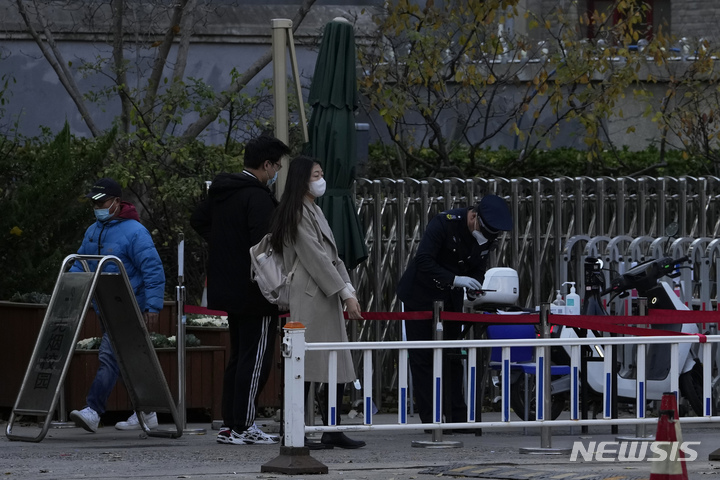 [베이징=AP/뉴시스]16일 중국 수도 베이징의 베이징대학 입구에서 방문객들이 경비원의 검문을 받고 있다. 국민들의 불만이 커지고 있음에도 불구 중국이 '제로 코로나' 정책을 고수하면서 신종 코로나19 환자 1명이 발생한 베이징대학이 16일 폐쇄됐다. 2022.11.16