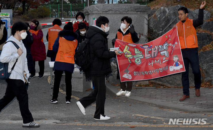 [광주=뉴시스] 변재훈 기자 = 2023학년도 대학수학능력시험일인 17일 오전 광주 광산구 26지구 11시험장(첨단고등학교) 앞에서 수험생들이 주민자생단체 응원을 받으며 시험장으로 향하고 있다. 2022.11.17. wisdom21@newsis.com