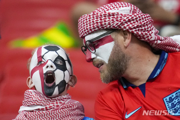 [알 라이얀=AP/뉴시스] 월드컵 B조 잉글랜드 팬들이 얼굴을 국기 색으로 칠하고 25일(현지시간) 카타르 알 코르의 알 바이트 스타디움에서 열린 미국과 잉글랜드 경기에 앞서 환호하고 있다. 2022.11.29.