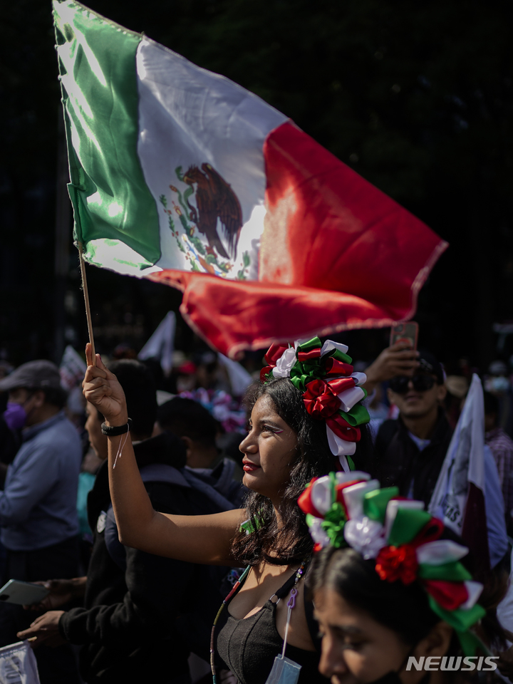 [멕시코시티= AP/뉴시스] 멕시코시티의  친정부 시위행진 참가자들이 27일(현지시간) 시내 중심가에서 로페스 오브라도르 대통령에 대한 지지 구호를 외치고 있다.  