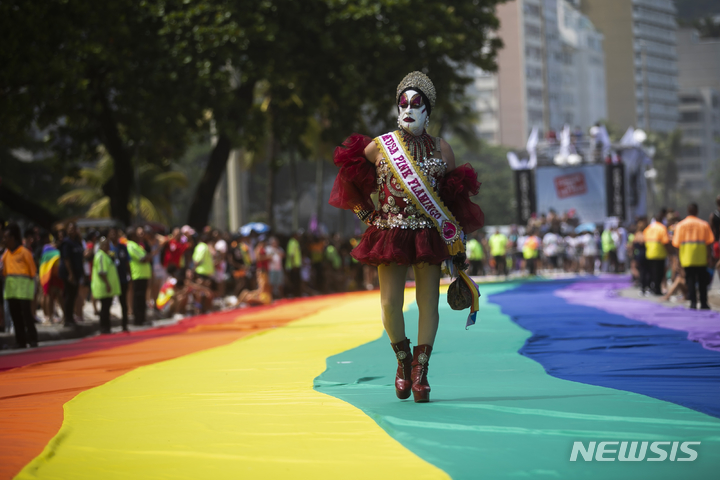 [리우데자네이루=AP/뉴시스] 27일(현지시간) 브라질 리우데자네이루 코파카바나 해변에서 제27회 게이 프라이드 퍼레이드(Gay Pride Parade)가 열린 가운데 한 참가자가 행진하고 있다. 2022.11.28.