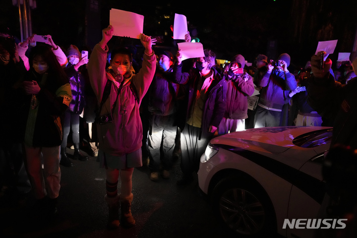 [베이징=AP/뉴시스]중국 수도 베이징에서 지난 27일 밤 시위대들이 백지를 들고 행진하고 있다. 2022.11.29.