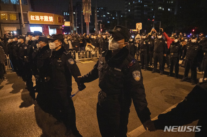 [베이징=AP/뉴시스]지난 27일 중국 수도 베이징에서 경찰이 시위대들을 막기 위해 손을 잡고 줄을 섰다. 2022.11.29.