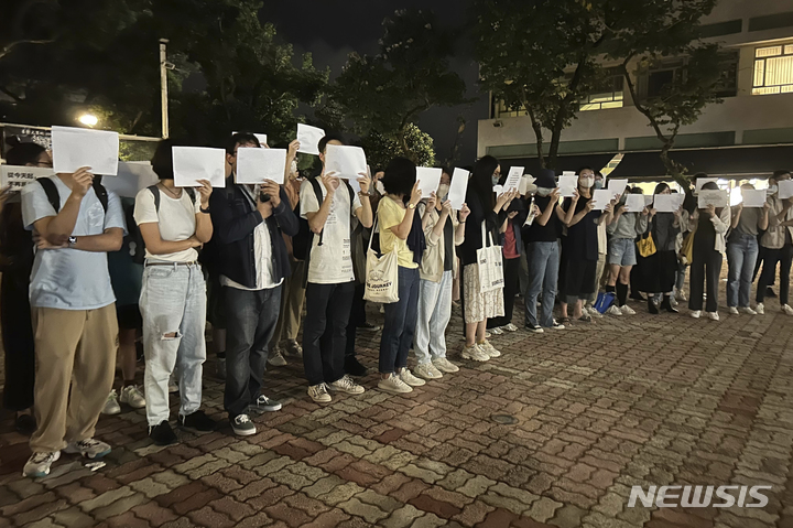 [홍콩=AP/뉴시스]시위자들이 28일 홍콩중문대학교에서 최근 발생한 우루무치 화재 희생자들을 추모하는 동안 백지를 들고 있다. 중국 본토의 몇몇 도시에서 집권 공산당을 반대하고 시진핑 주석의 사임을 요구하는 시위가 열리자, 홍콩 학생들은 중국의 코로나 바이러스 통제에 반대하는 시위를 갖고 "독재 반대"를 외쳤다. 2022.11.29.